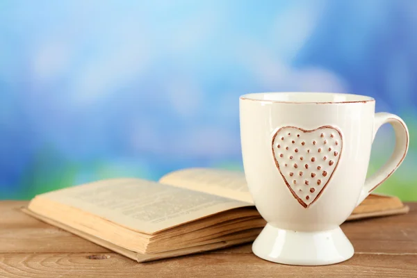 Tasse de thé et livre sur table, sur fond lumineux — Photo