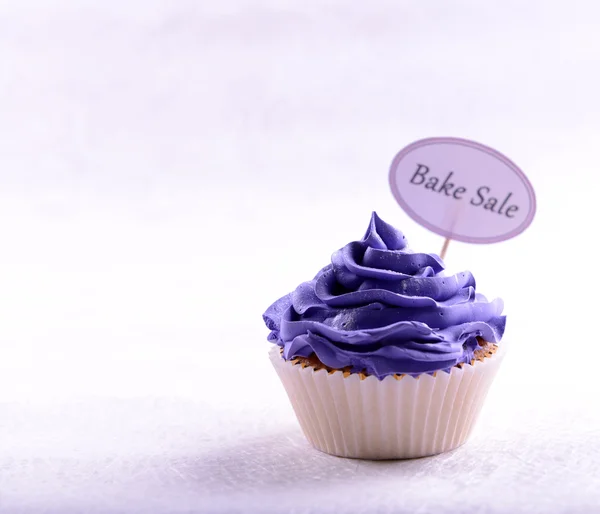 Delicious cupcake with inscription on table on beige background — Stock Photo, Image