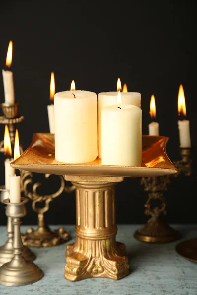 Bougeoirs rétro avec bougies sur table en bois, sur fond noir — Photo