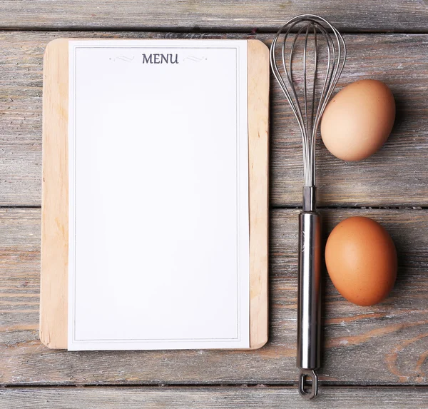 Placa de corte com folha de menu de papel em tábuas de madeira rústica fundo — Fotografia de Stock