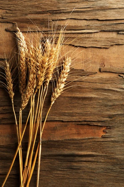 Espiguillas de trigo sobre fondo de madera — Foto de Stock