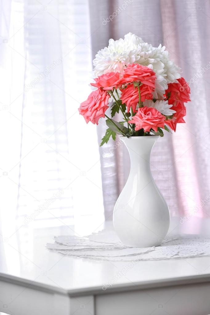 Beautiful flowers in vase with light from window