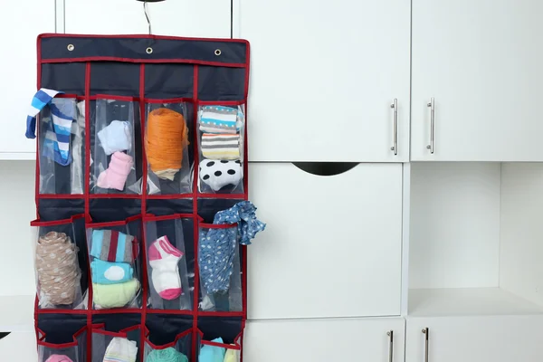 Different socks in hanging bag on closet background — Stock Photo, Image