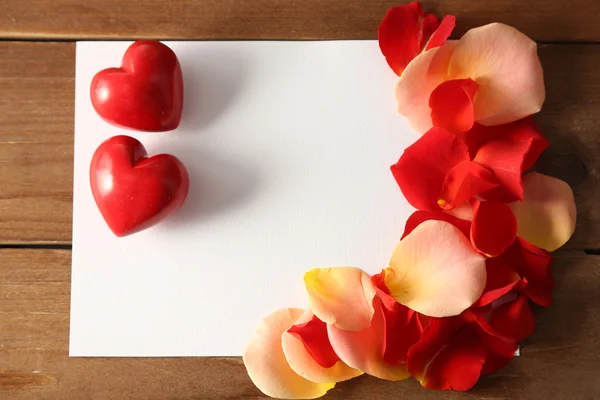 Hermosa tarjeta postal hecha a mano con pétalos de rosa sobre fondo de madera de color —  Fotos de Stock