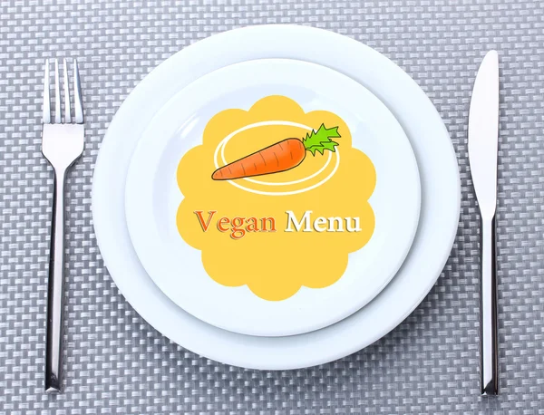 Placa com texto "Menu Vegan", garfo e faca sobre fundo de toalha de mesa — Fotografia de Stock