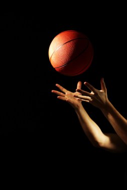 Koyu arka plan üzerinde topu ile basketbol oyuncusu