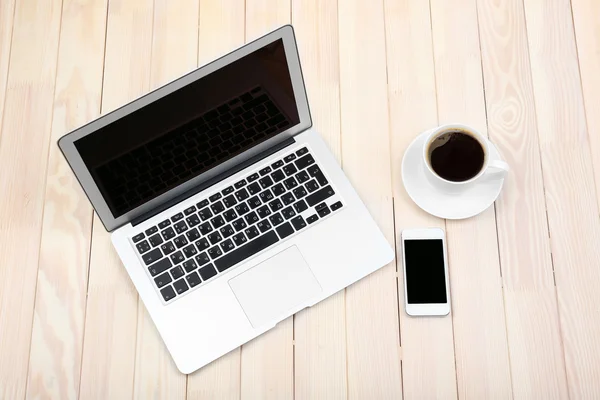 Notebook aberto, tablet digital, diário, telefone inteligente e uma xícara de café em fundo de madeira, vista superior — Fotografia de Stock