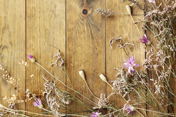 素朴な木製の板の背景にドライフラワー — ストック写真