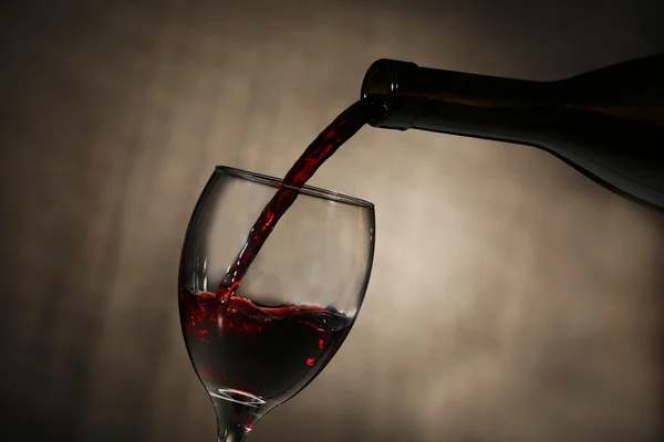 Pouring red wine from bottle — Stock Photo, Image