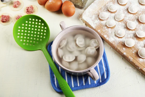 Raw and cooked dumplings close-up in kitchen — Stock Photo, Image