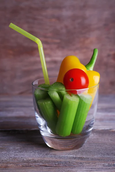 Sticks of celery with sweet pepper and cherry tomato in glass with tube on rustic wooden background — Stock Photo, Image