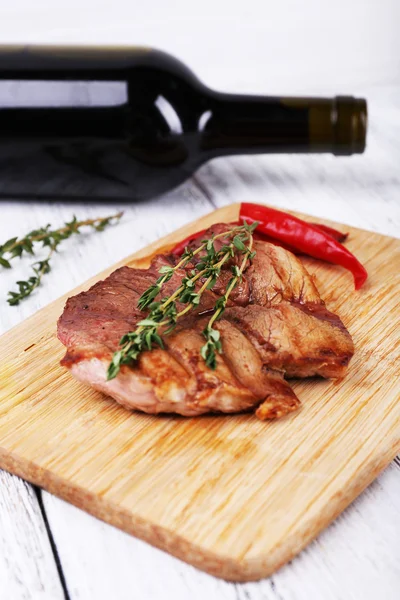 Steak with herbs on wooden stand — Stock Photo, Image