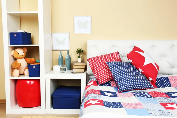 Modern colorful bedroom interior with bed and nightstand, with design details on light wall background — Stock Photo, Image