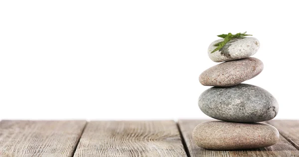 Still life of spa stones on wooden planks surface isolated on white — Stock Photo, Image