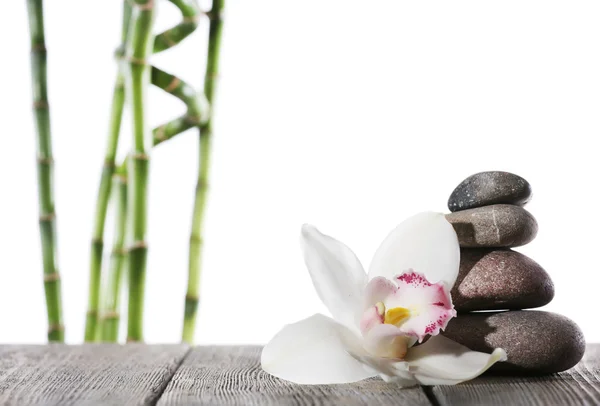 Stilleven van spa stenen op houten planken oppervlak met bamboestokken geïsoleerd op wit — Stockfoto