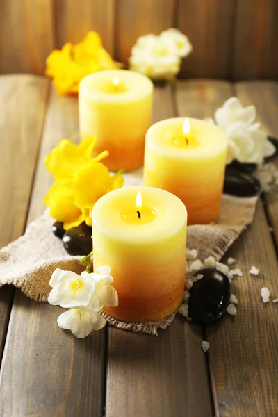 Beautiful candles with flowers on wooden background — Stock Photo, Image