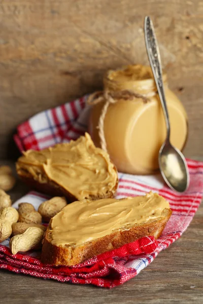 Mantequilla de cacahuete fresca en frasco sobre fondo de madera — Foto de Stock