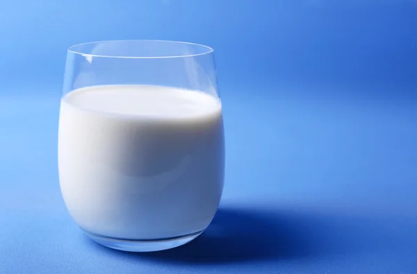 Milk in glass on blue background — Stock Photo, Image