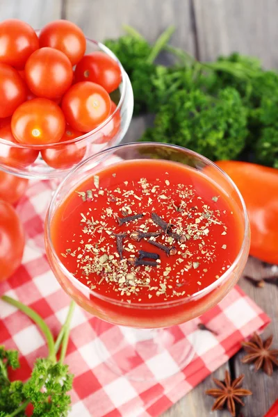 Tomatensaft im Kelch und frisches Gemüse auf Serviette auf hölzernem Hintergrund — Stockfoto