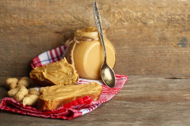 Ahşap arka plan üzerinde kavanoza taze fıstık ezmesi