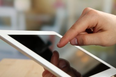 Ahşap masa ve ışık arka plan bulanık Tablet Pc kullanarak el