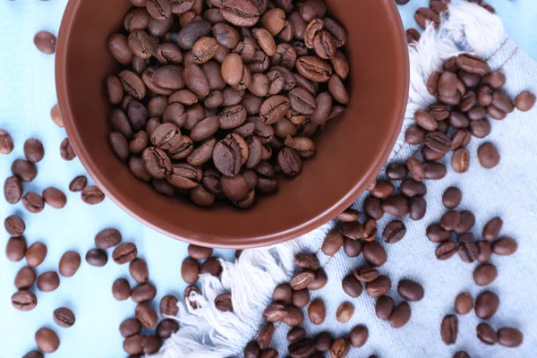 Kom gemalen koffie en koffiebonen op blauwe houten achtergrond met jeans materiaal — Stockfoto