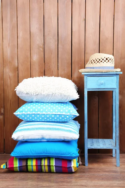Colina de almohadas de colores sobre fondo rústico de madera — Foto de Stock