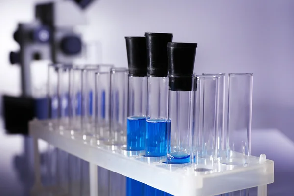 Laboratory glassware with blue liquid on gray background — 스톡 사진