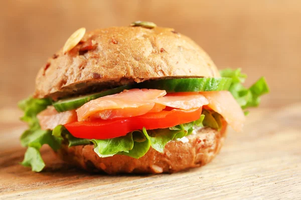 Sandwich con salmón sobre fondo de madera — Foto de Stock