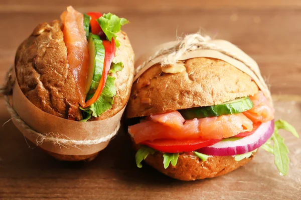 Sandwiches with salmon on wooden background — Stock Photo, Image