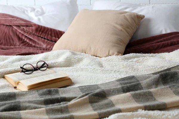 Книга і окуляри на ліжку крупним планом — стокове фото