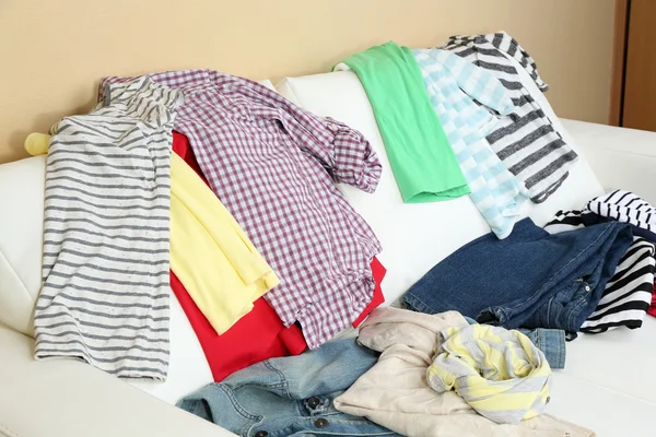 Messy clothing on white sofa — Stock Photo, Image