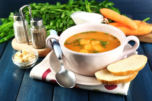 Composition with carrot soup, ingredients and herbs on color wooden background — Stock Photo, Image