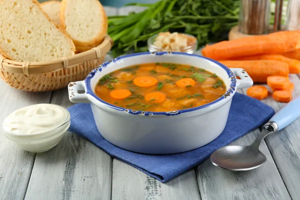 Composición con sopa de zanahoria, ingredientes y hierbas sobre fondo de madera de color — Foto de Stock