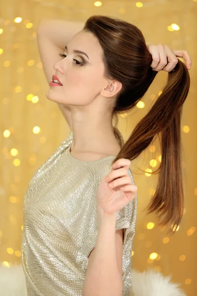 Piękna młoda kobieta z długimi włosami na jasnym tle — Zdjęcie stockowe