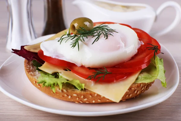 Sandwich mit pochiertem Ei und Gemüse auf Teller auf Holzgrund — Stockfoto