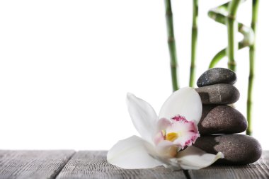 Natürmort spa taş ahşap plakalar yüzeyi üzerinde beyaz izole bambu sopayla