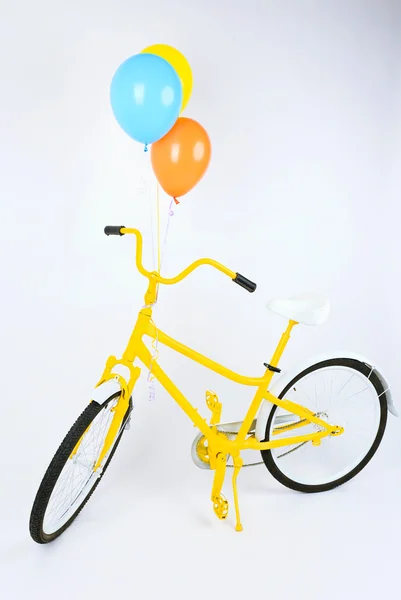 Bicicleta amarela com balões — Fotografia de Stock