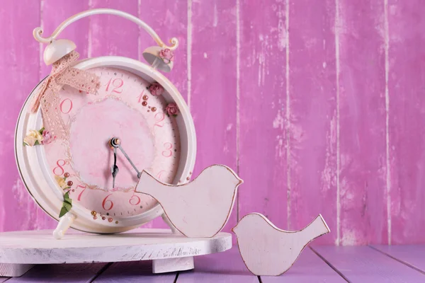 Belle horloge vintage avec des oiseaux décoratifs sur table sur fond en bois — Photo