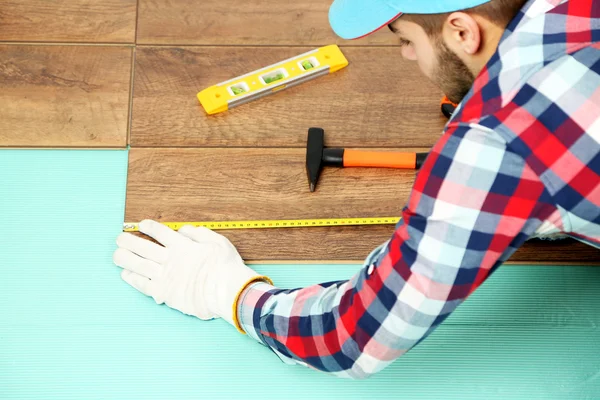 Carpenter worker installing laminate flooring — Stock Photo, Image