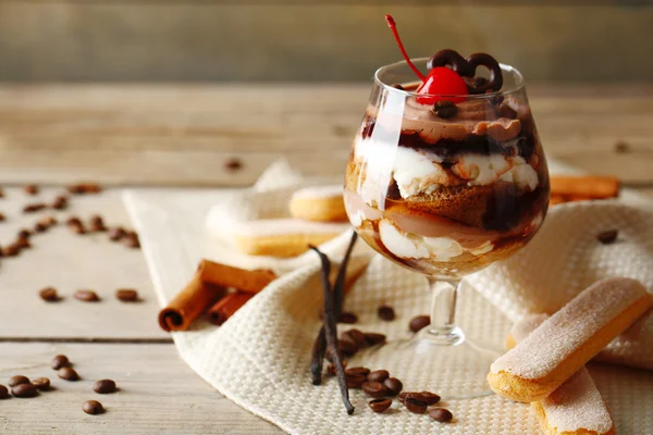 Tasty tiramisu dessert in glass, on wooden background — Stock Photo, Image