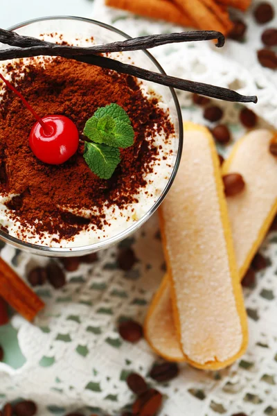 Tasty tiramisu dessert in glass, on napkin, on wooden background — Stock Photo, Image