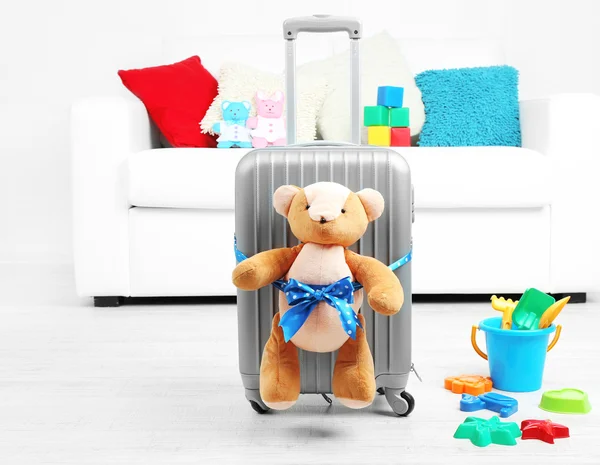 Suitcase with teddy bear and child toys in room on white sofa background — Stock Photo, Image