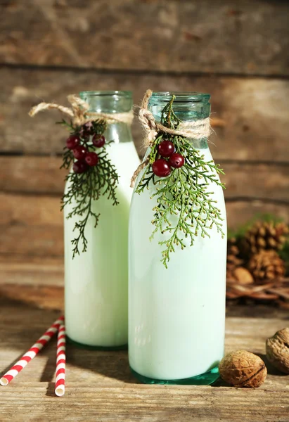 Bouteilles de lait frais au décor naturel, sur fond de bois — Photo