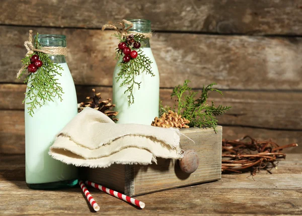 Bouteilles de lait frais au décor naturel, sur fond de bois — Photo