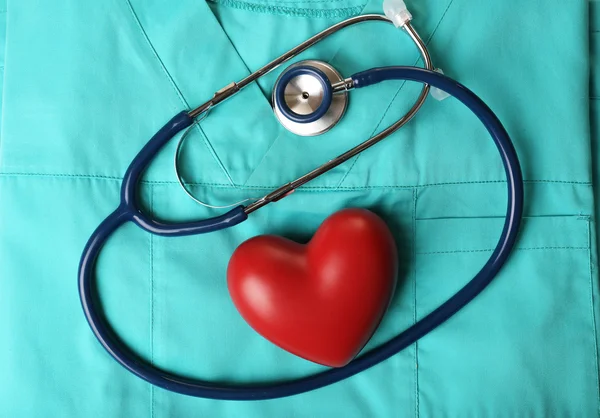 Stetoskop ile takım elbise arka plan üzerinde kalp yakın çekim — Stok fotoğraf