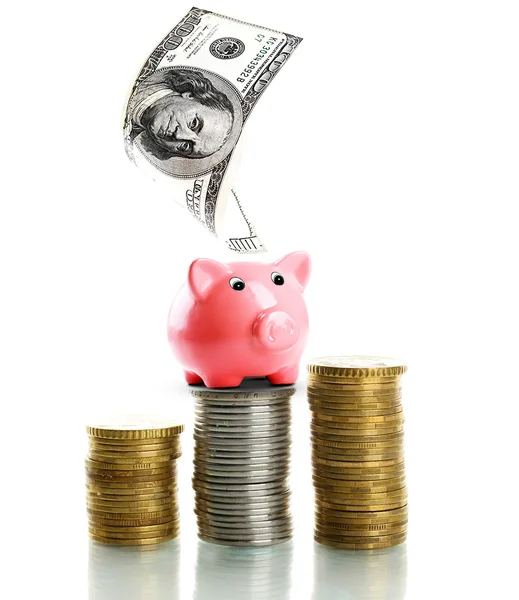 Piggy bank staande op stapel van munten geïsoleerd op wit — Stockfoto