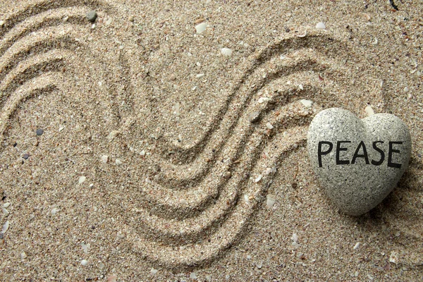 Pietra zen grigia a forma di cuore, su sfondo di sabbia — Foto Stock