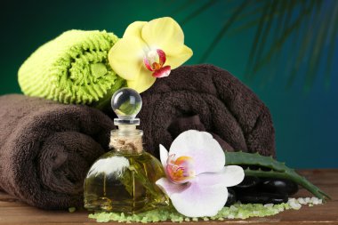 Spa uygulamaları ile renkli arka plan üzerinde ahşap masaya orkide çiçek