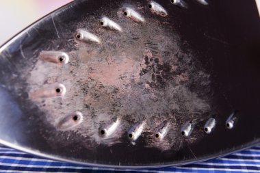 Kumaş arka plan üzerinde yanmış işareti bulunan yassı demir